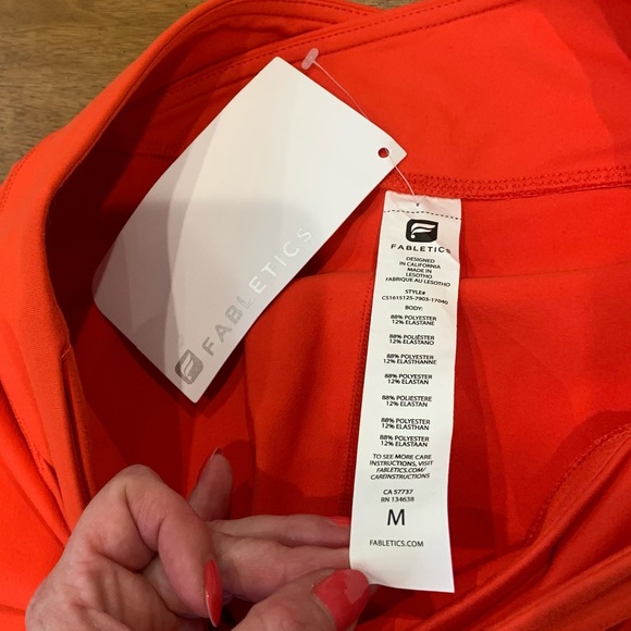 Fabletics Midrise Capris in orange with crossover waistband and hidden pocket - Picture 7 of 8